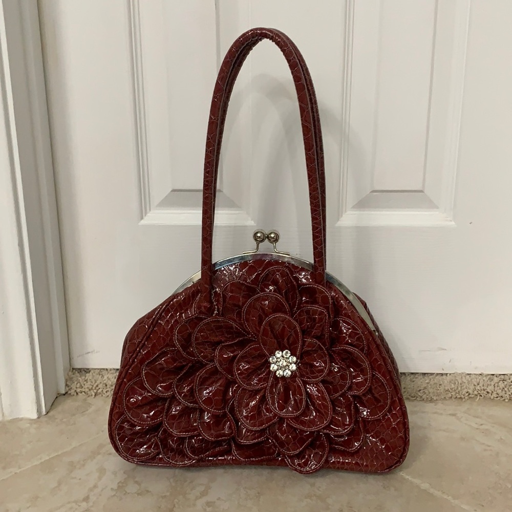 Dark Red Purse with Flower-like embellishment.